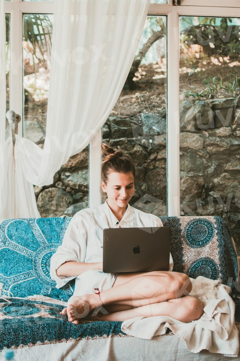 Mujer sentada escribiendo en laptop